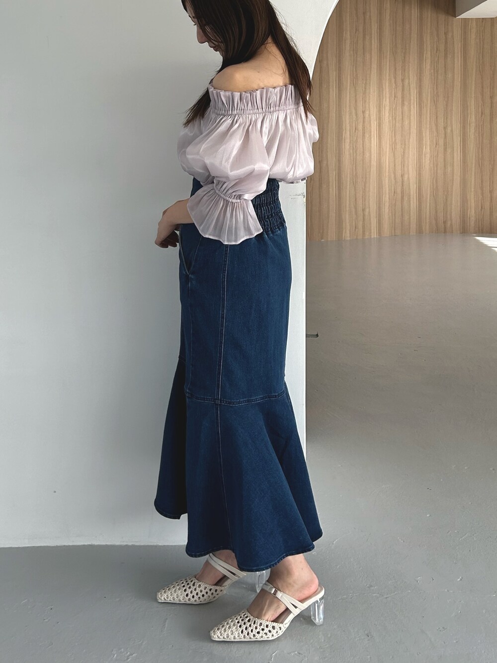 パープル系のシャツ/ブラウス、ブルー系のデニムスカート、ホワイト系のパンプスを着用したレディースの春コーディネートの5枚目の写真