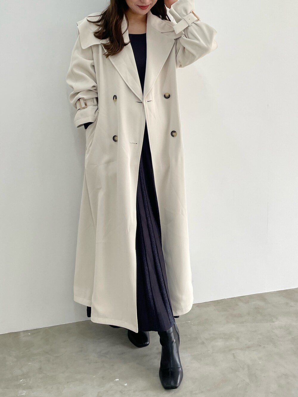 グレー系のワンピース、ホワイト系のトレンチコートを着用したレディースの冬コーディネートの6枚目の写真