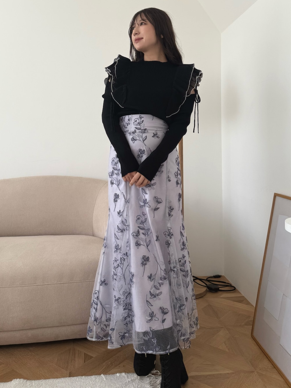 ブラック系のニット/セーター、パープル系のスカート、ブラック系のブーツを着用したレディースの秋コーディネートの2枚目の写真