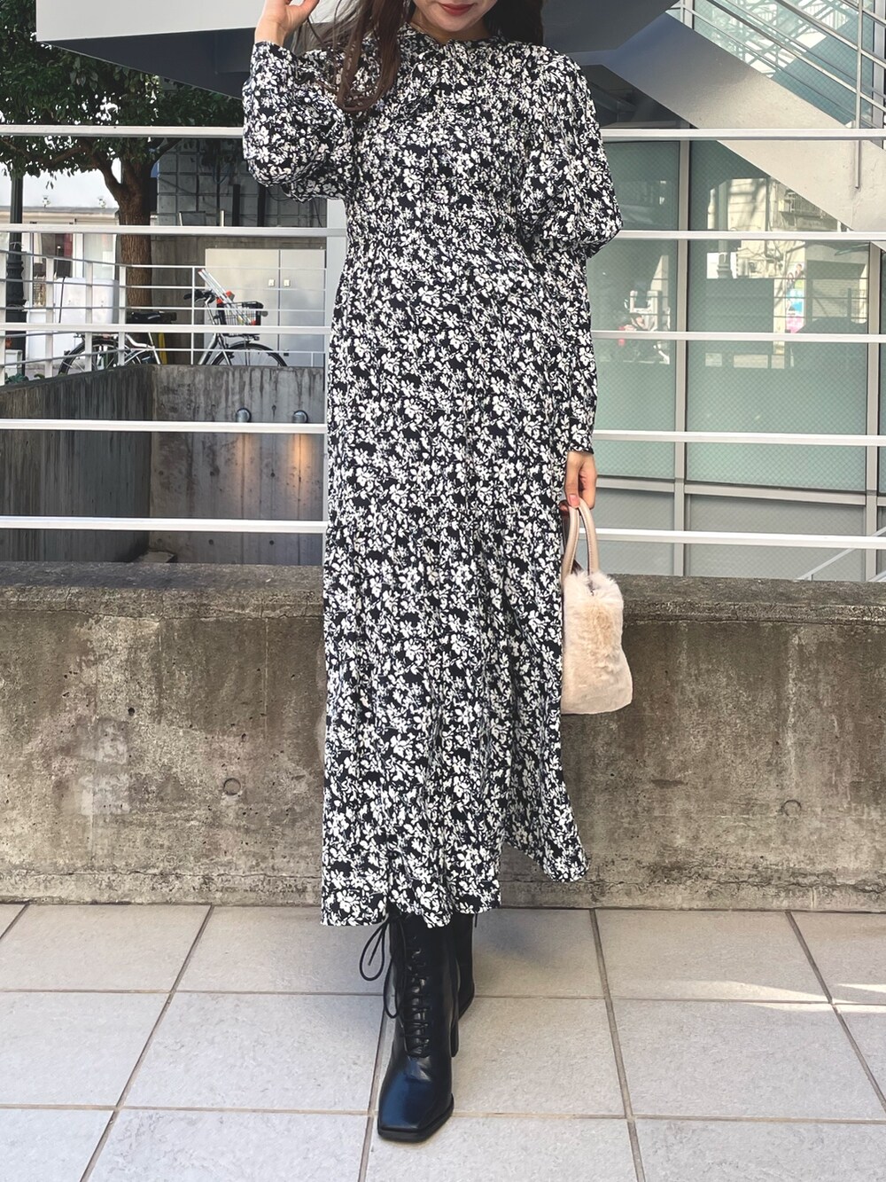 ホワイト系のチェスターコート、ブラック系のワンピース、ブラック系のブーツを着用したレディースの冬コーディネートの4枚目の写真