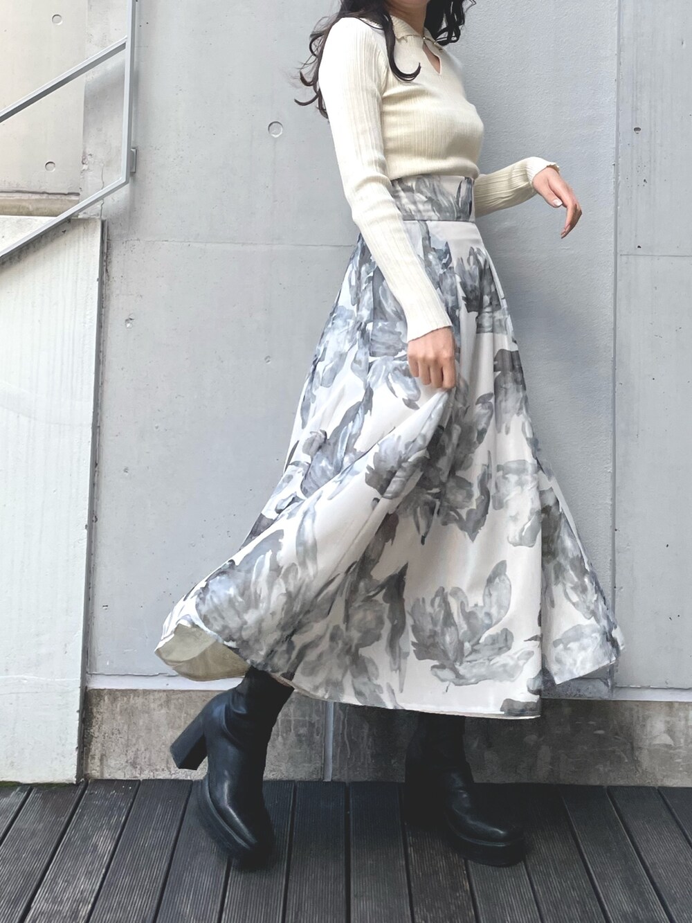 イエロー系のニット/セーター、ホワイト系のスカートを着用したレディースの冬コーディネートの2枚目の写真
