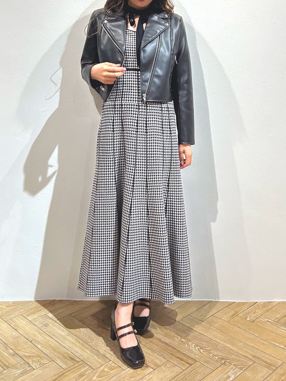 ブラック系のワンピース、ブラック系のライダースジャケット、レッド系のパンプスを着用したレディースの秋コーディネートの2枚目の写真