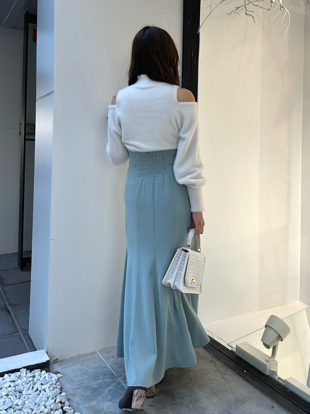 ホワイト系のニット/セーター、グリーン系のスカート、ホワイト系のショルダーバッグを着用したレディースの冬コーディネートの4枚目の写真