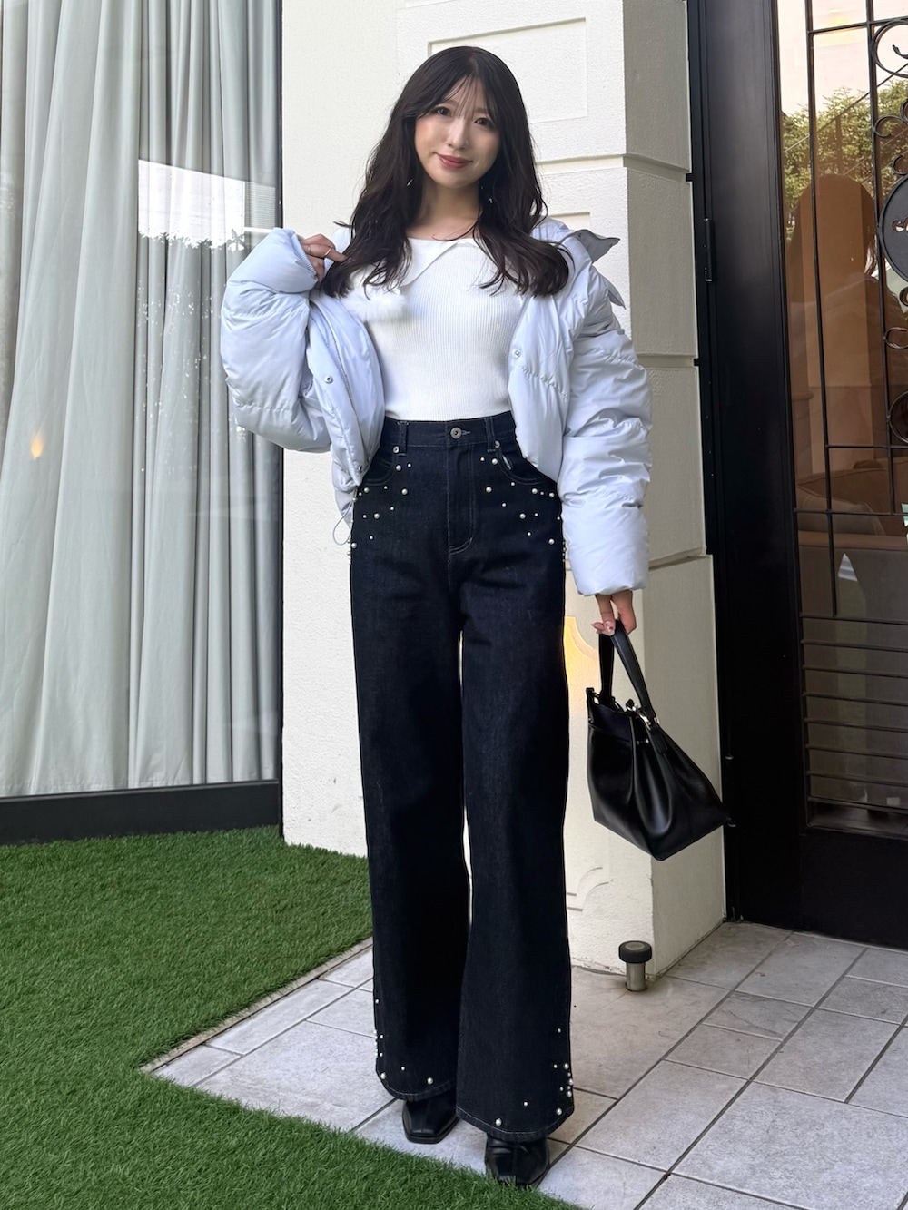 ホワイト系のニット/セーター、ブルー系のダウンジャケット/コート、ブルー系のデニムパンツを着用したレディースの秋コーディネートの4枚目の写真