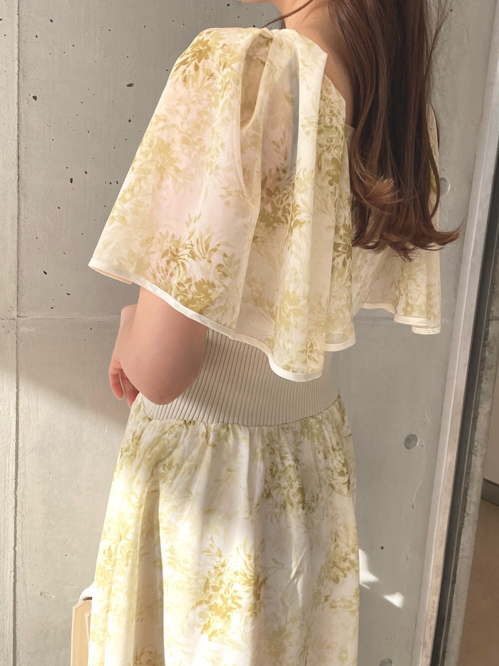 ホワイト系のハンドバッグ、イエロー系のワンピース、ホワイト系のサンダルを着用したレディースの春コーディネートの6枚目の写真