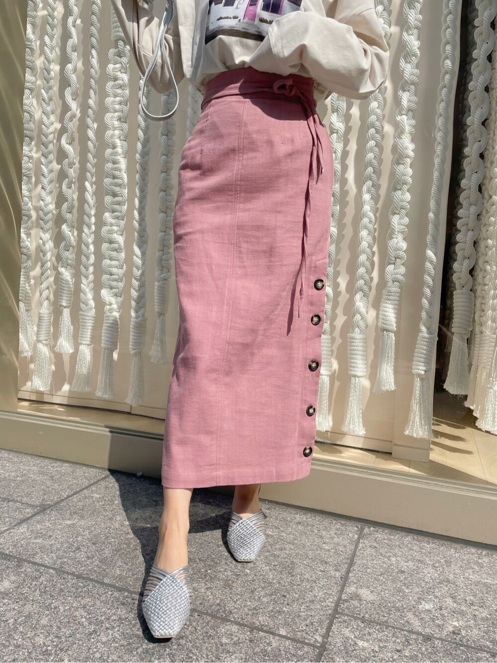 シルバー系のサンダル、ベージュ系のTシャツ/カットソー、ピンク系のスカートを着用したレディースの春コーディネートの4枚目の写真