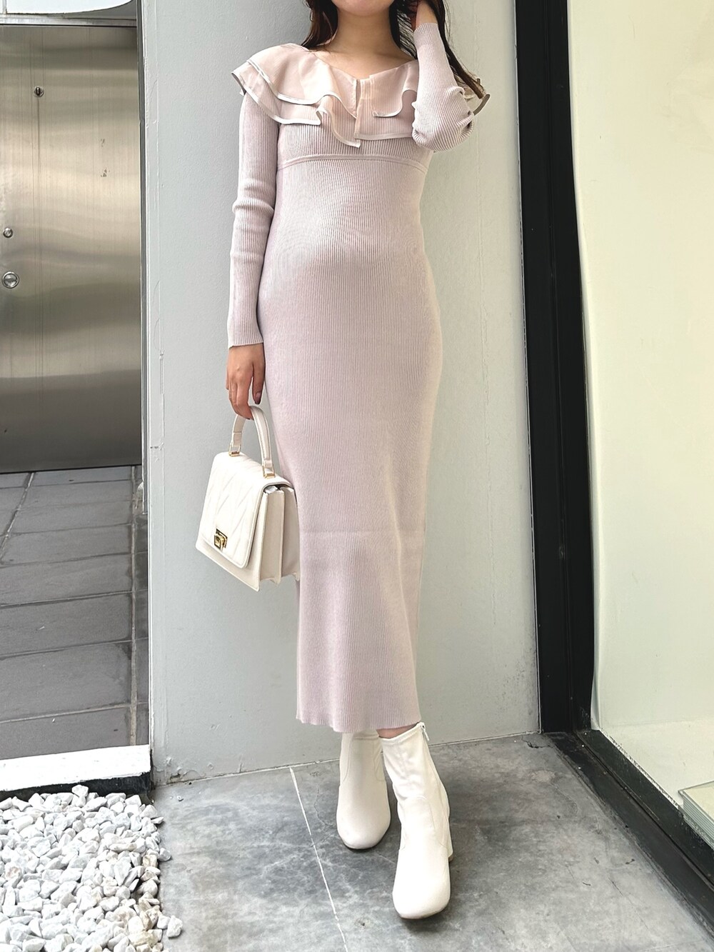 ピンク系のワンピース、ホワイト系のショルダーバッグ、ホワイト系のダウンジャケット/コートを着用したレディースの冬コーディネートの4枚目の写真