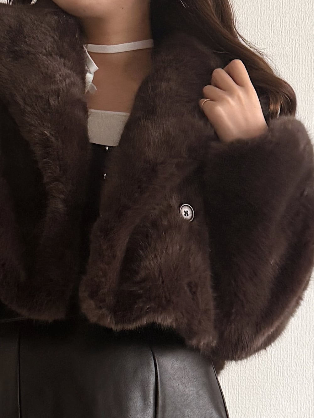 ブルー系のニット/セーター、ブラウン系のその他アウター、ブラック系のスカートを着用したレディースの秋コーディネートの6枚目の写真