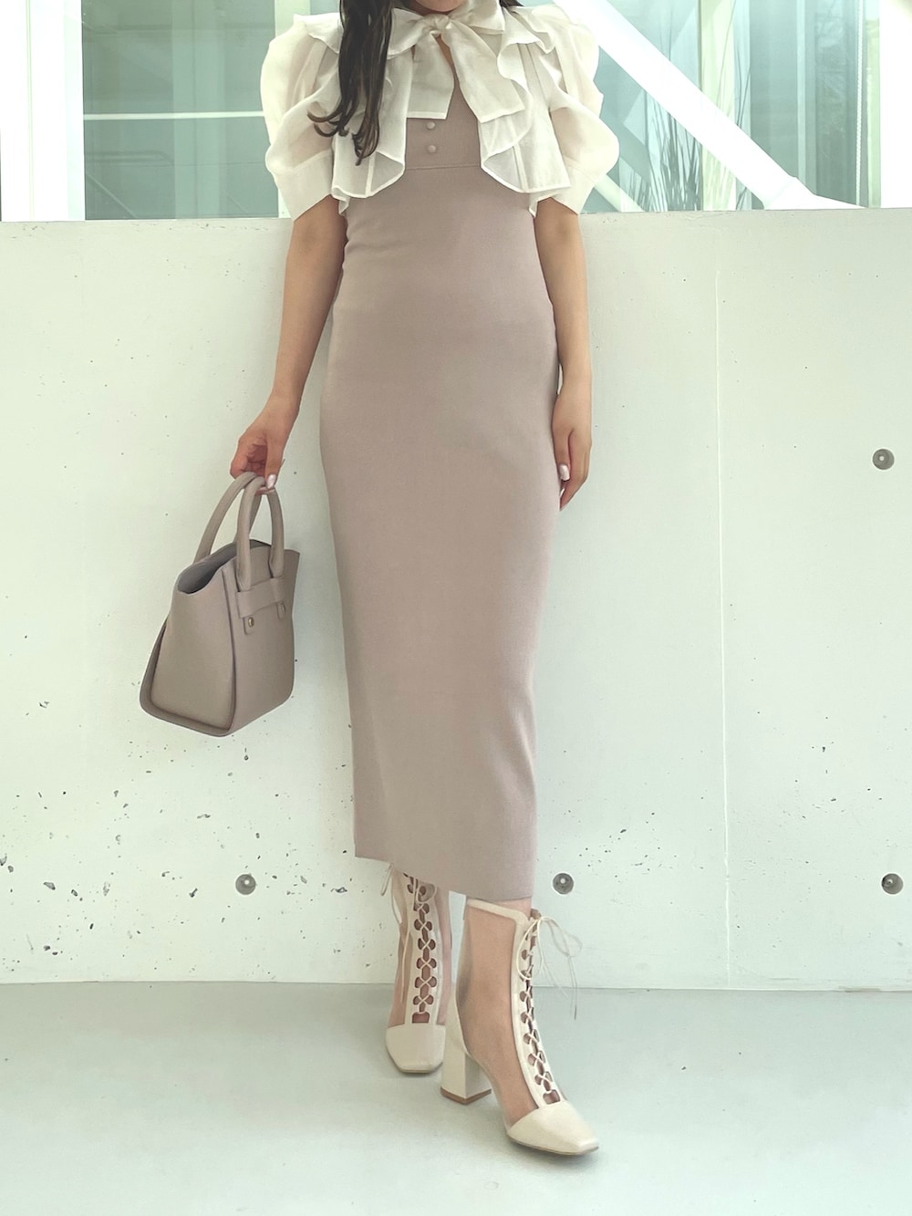ホワイト系のブーツ、ベージュ系のワンピース、ベージュ系のハンドバッグを着用したレディースの夏コーディネートの2枚目の写真