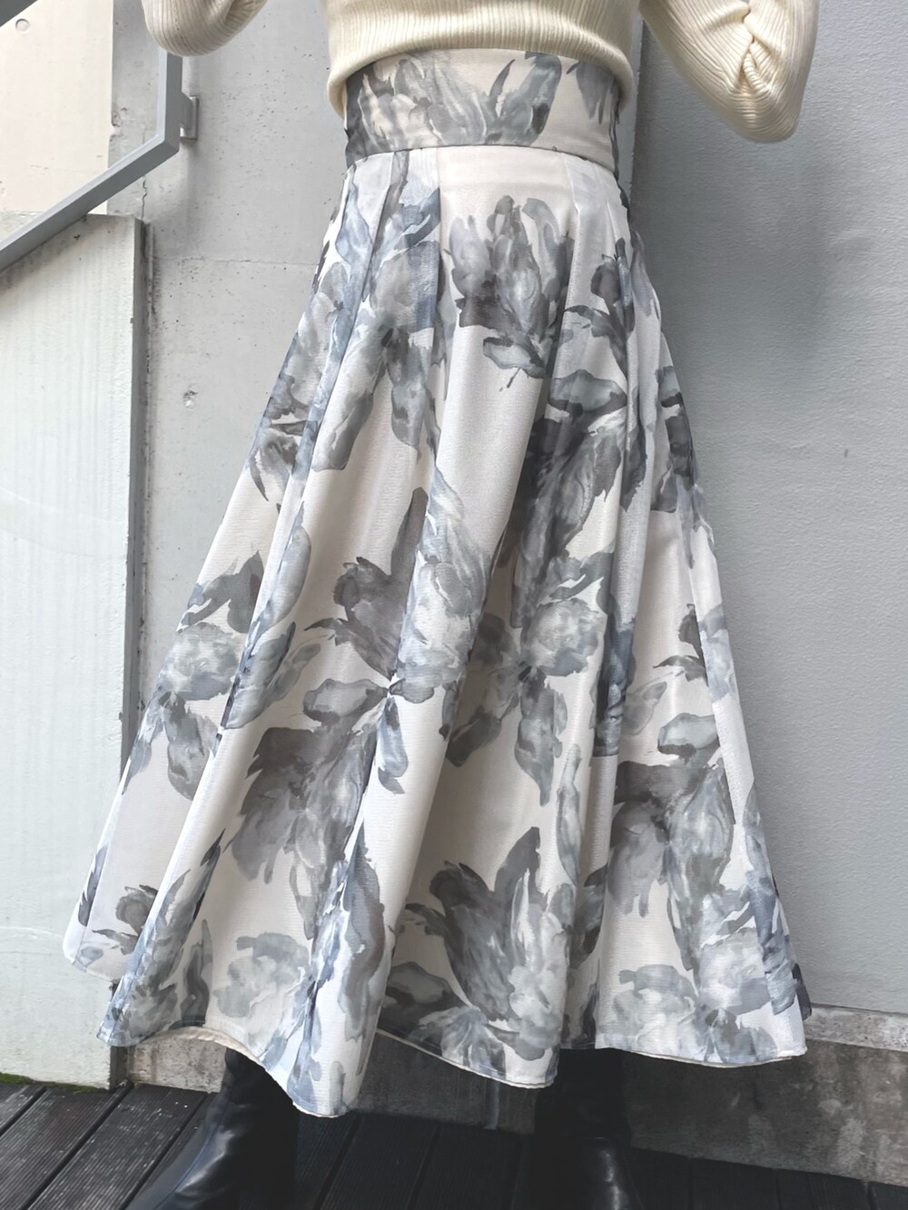 イエロー系のニット/セーター、ホワイト系のスカートを着用したレディースの冬コーディネートの6枚目の写真