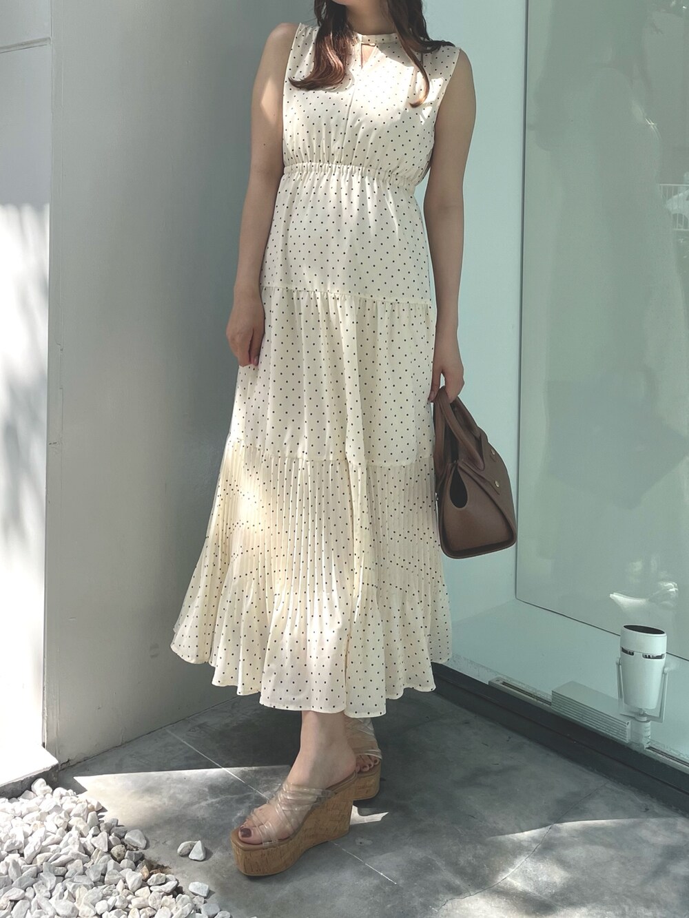 ベージュ系のワンピース、ブラウン系のトートバッグ、ホワイト系のサンダルを着用したレディースの夏コーディネートの3枚目の写真