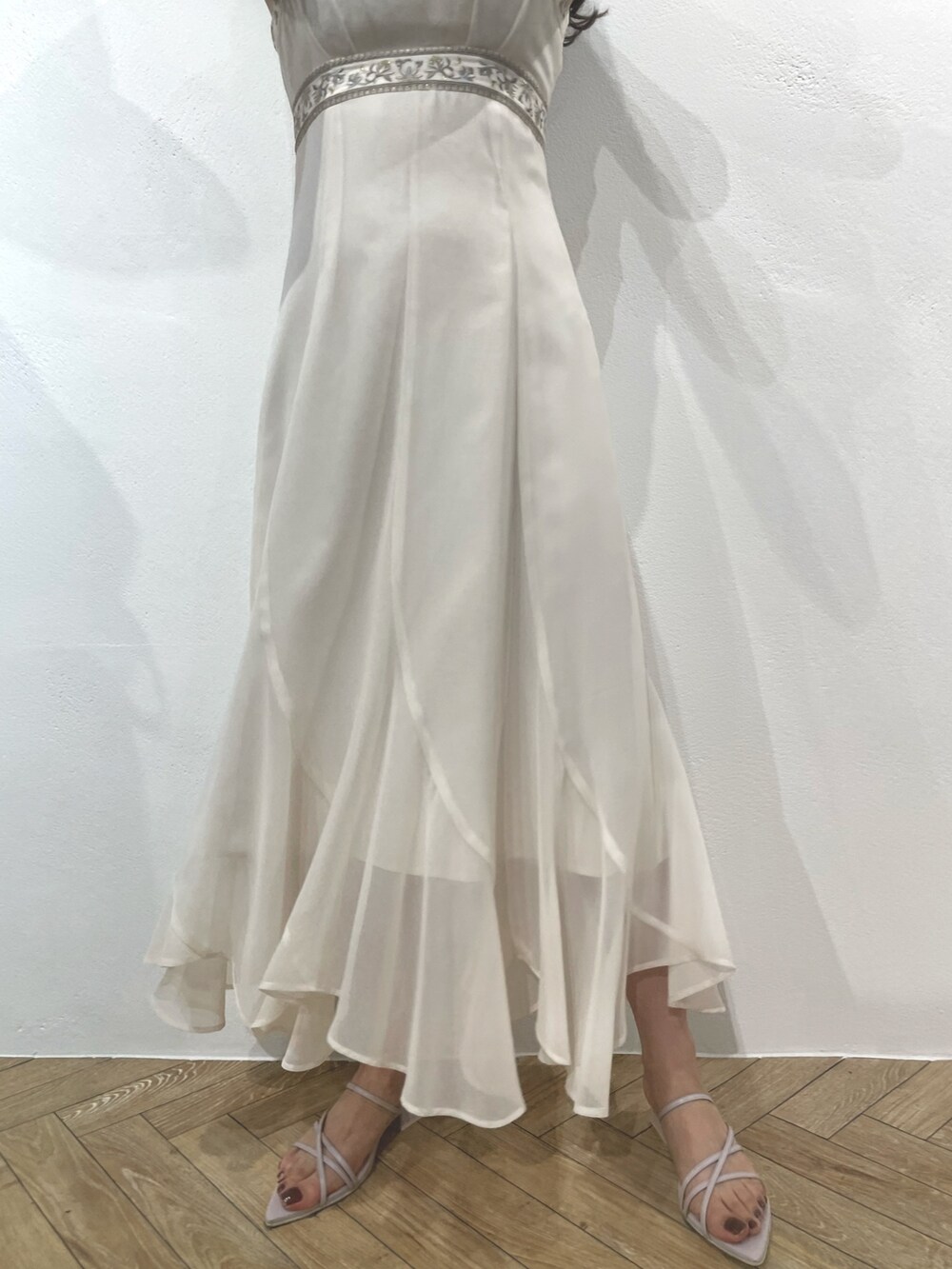 パープル系のサンダル、ホワイト系のドレス、パープル系のハンドバッグを着用したレディースの春コーディネートの4枚目の写真