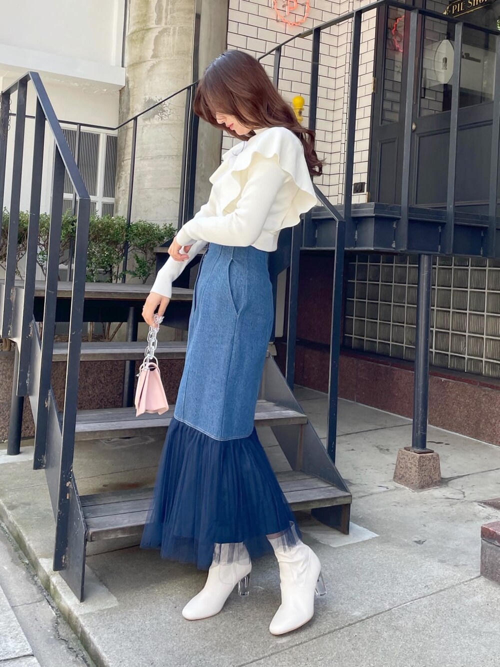 ブルー系のスカート、ホワイト系のその他シューズ、ピンク系のショルダーバッグを着用したレディースの冬コーディネートの2枚目の写真