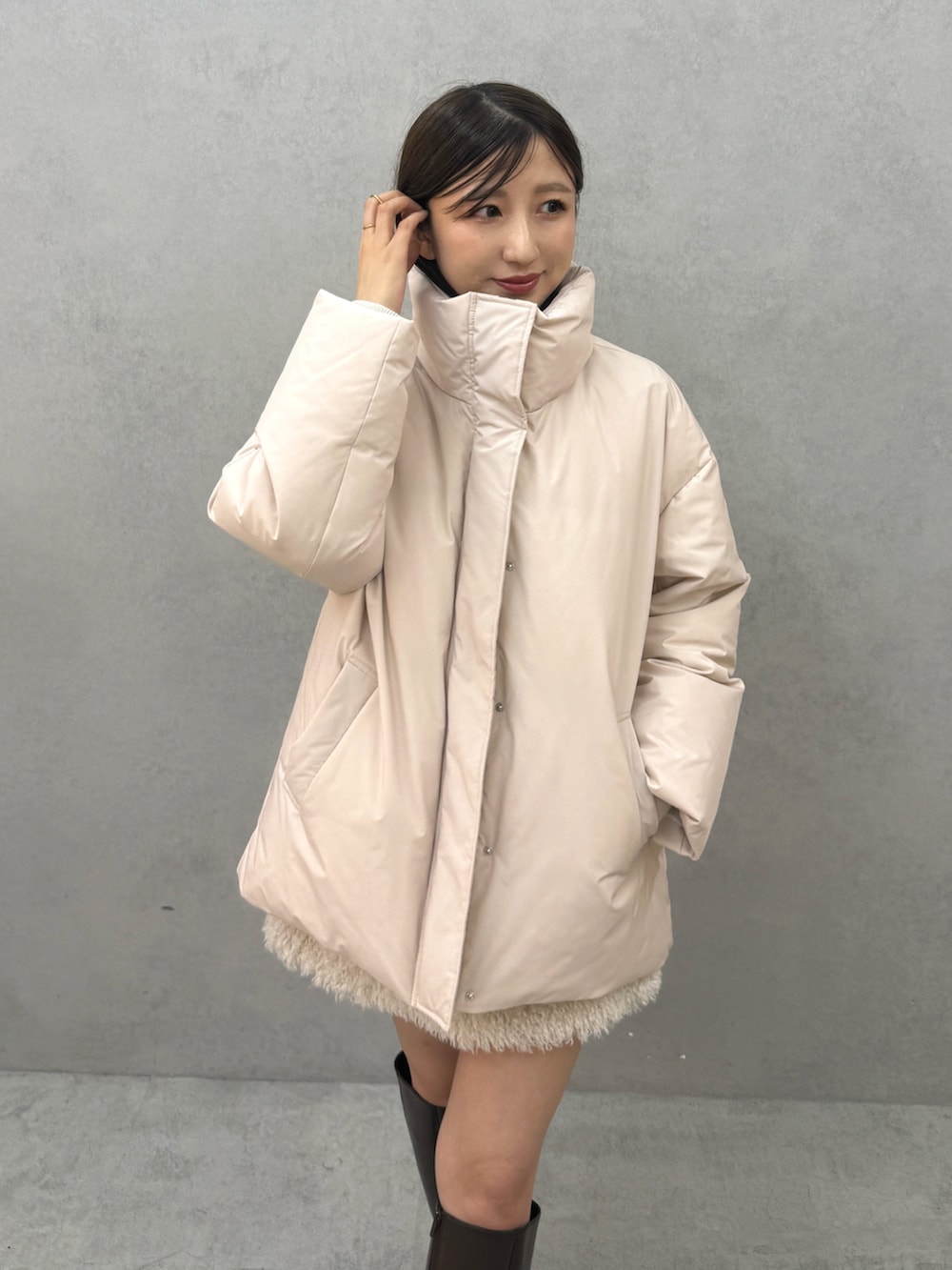 ピンク系のダウンジャケット/コート、ホワイト系のスカート、ブラウン系のブーツを着用したレディースの秋コーディネートの5枚目の写真