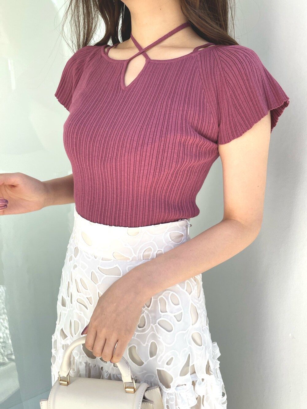 ピンク系のニット/セーター、ホワイト系のハンドバッグ、ホワイト系のスカートを着用したレディースの春コーディネートの5枚目の写真