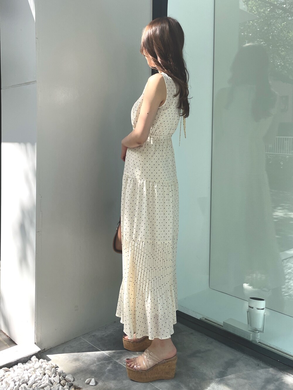 ベージュ系のワンピース、ブラウン系のトートバッグ、ホワイト系のサンダルを着用したレディースの夏コーディネートの4枚目の写真