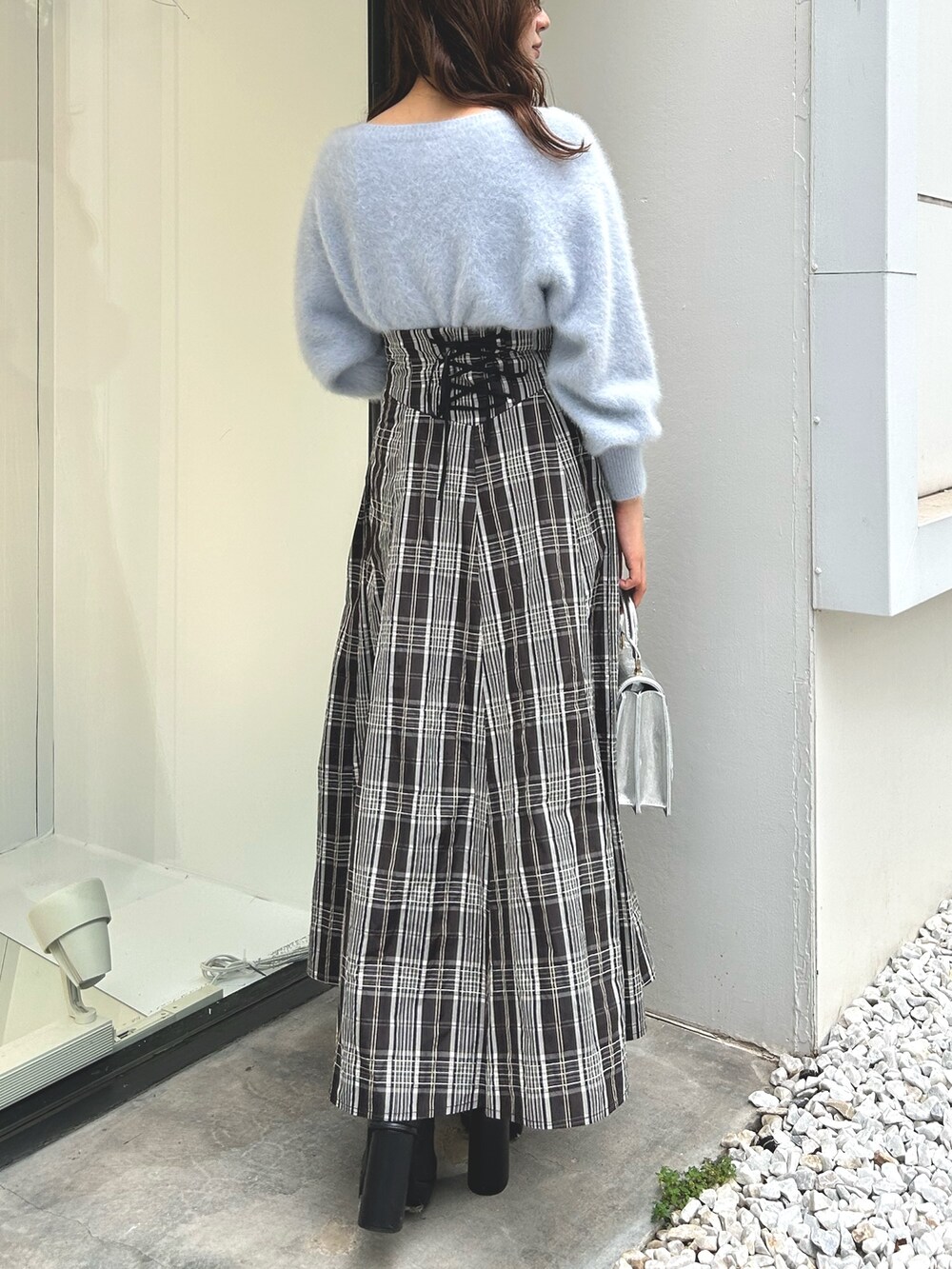 ブルー系のカーディガン/ボレロ、ブラック系のスカート、シルバー系のハンドバッグを着用したレディースの秋コーディネートの3枚目の写真