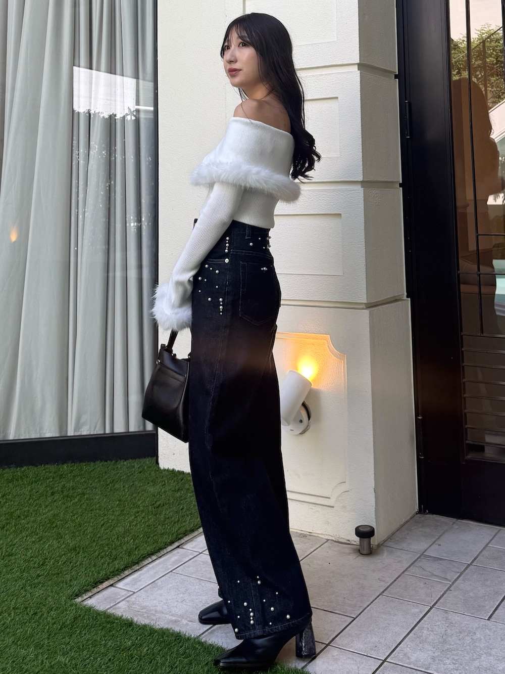 ホワイト系のニット/セーター、ブルー系のダウンジャケット/コート、ブルー系のデニムパンツを着用したレディースの秋コーディネートの2枚目の写真