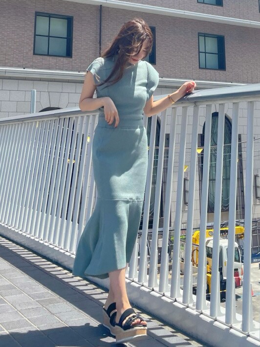 グリーン系のワンピースを着用したレディースの春コーディネートの2枚目の写真