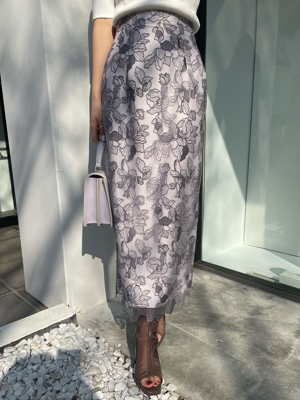 ホワイト系のスカート、ホワイト系のニット/セーター、ブラック系のブーツを着用したレディースの春コーディネートの5枚目の写真