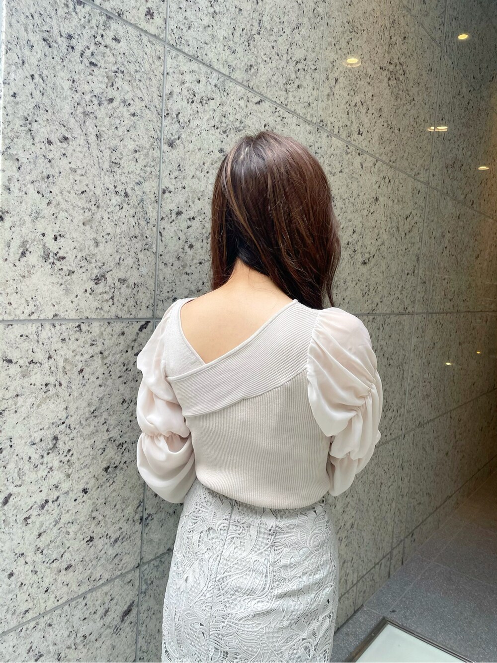 グリーン系のトートバッグ、ベージュ系のニット/セーターを着用したレディースの冬コーディネートの6枚目の写真