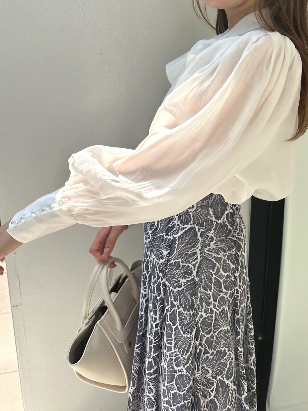 ブラック系のライダースジャケット、ホワイト系のシャツ/ブラウス、ブルー系のスカートを着用したレディースの夏コーディネートの7枚目の写真