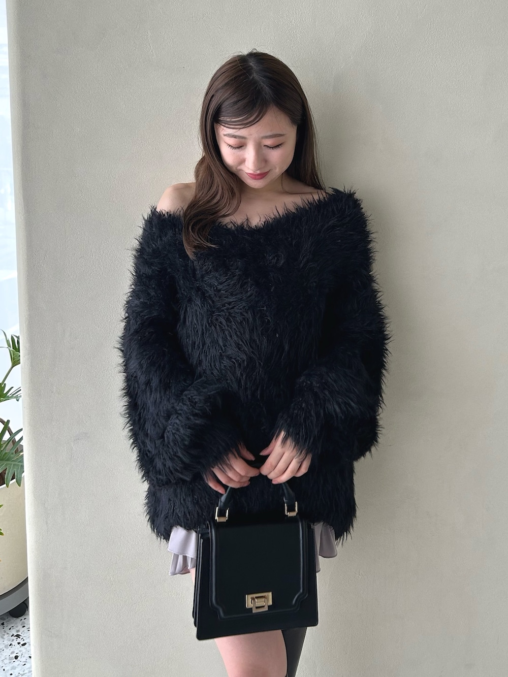 ピンク系のスカート、ブラック系のニット/セーター、ブラウン系のブーツを着用したレディースの冬コーディネートの4枚目の写真