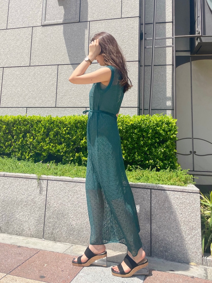 グリーン系のワンピース、ブラック系のサンダルを着用したレディースの春コーディネートの3枚目の写真