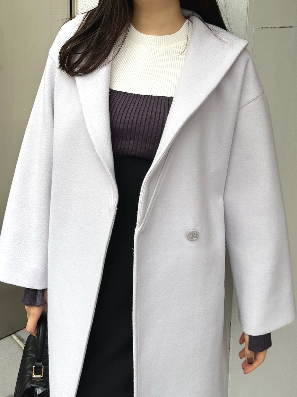 グレー系のニット/セーター、ブラック系のスカート、ブラック系のショルダーバッグを着用したレディースの冬コーディネートの9枚目の写真