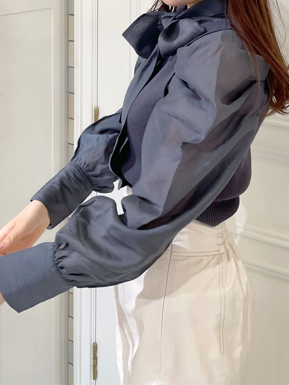 ホワイト系のスカート、ブルー系のニット/セーターを着用したレディースの冬コーディネートの5枚目の写真