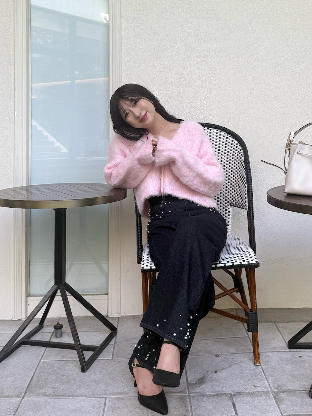 ピンク系のカーディガン/ボレロ、ブルー系のデニムパンツ、ブラック系のパンプスを着用したレディースの秋コーディネートの6枚目の写真
