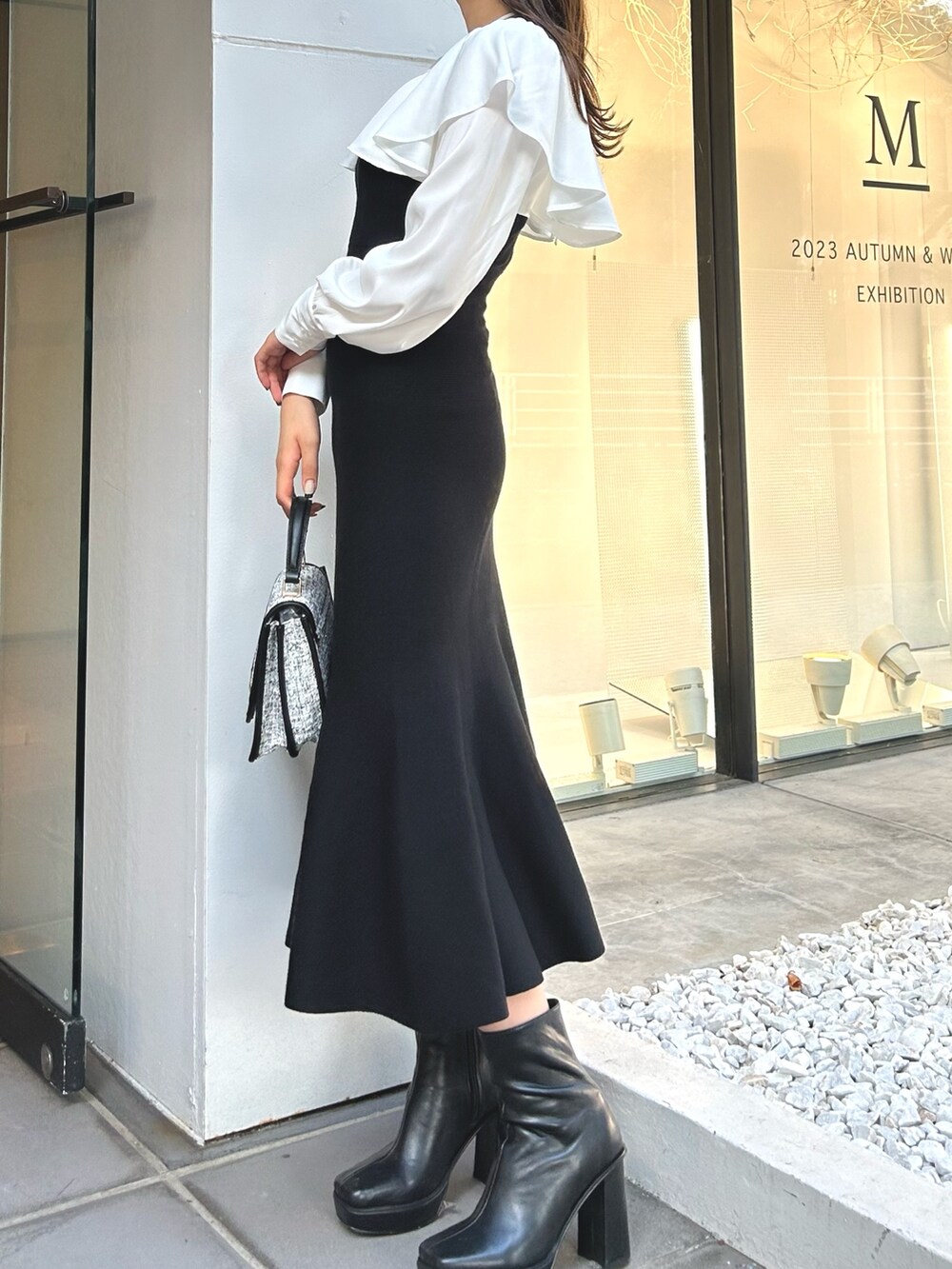 ブラック系のワンピース、ブラック系のショルダーバッグ、ブラック系のブーツを着用したレディースの秋コーディネートの3枚目の写真