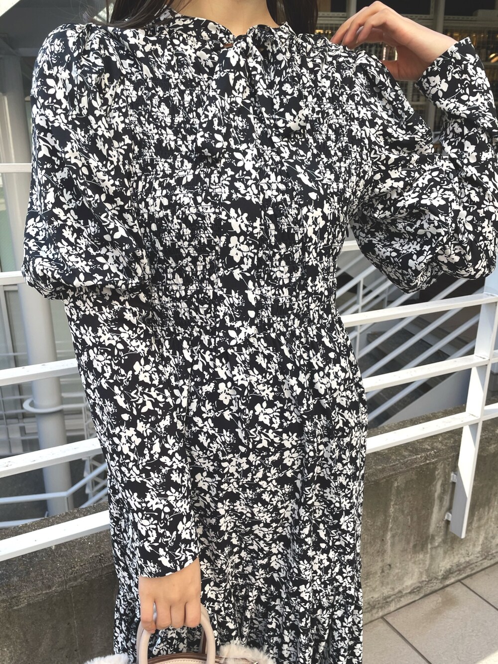 ホワイト系のチェスターコート、ブラック系のワンピース、ブラック系のブーツを着用したレディースの冬コーディネートの6枚目の写真