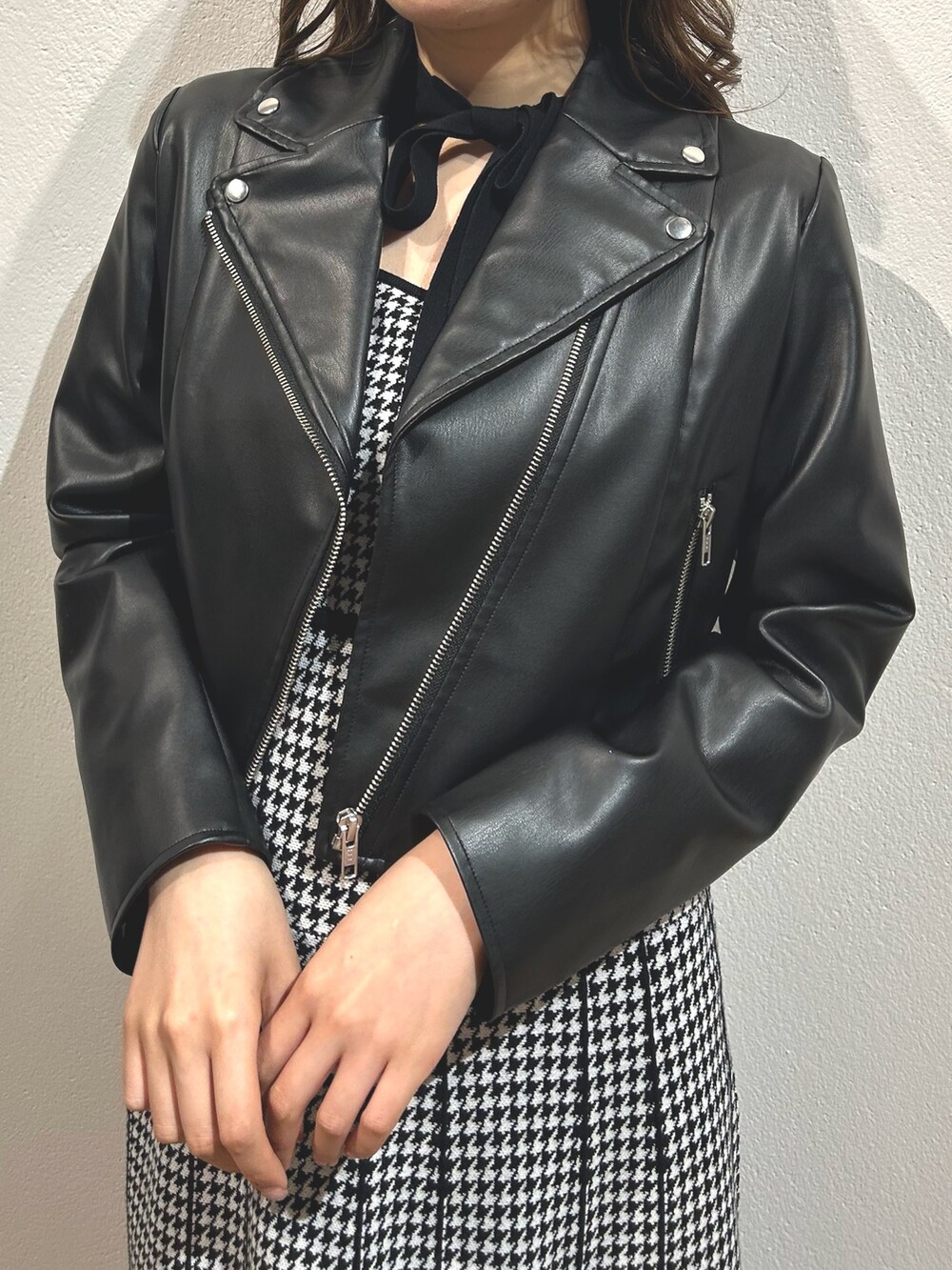 ブラック系のワンピース、ブラック系のライダースジャケット、レッド系のパンプスを着用したレディースの秋コーディネートの4枚目の写真