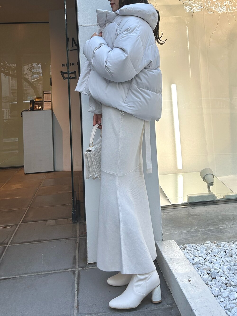 ホワイト系のワンピース、ホワイト系のダウンジャケット/コート、ホワイト系のショルダーバッグを着用したレディースの秋コーディネートの10枚目の写真