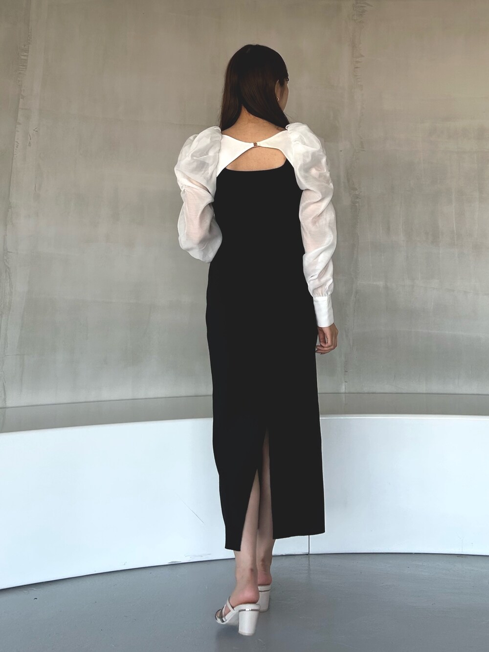 ブラック系のワンピース、ホワイト系のサンダルを着用したレディースの冬コーディネートの3枚目の写真