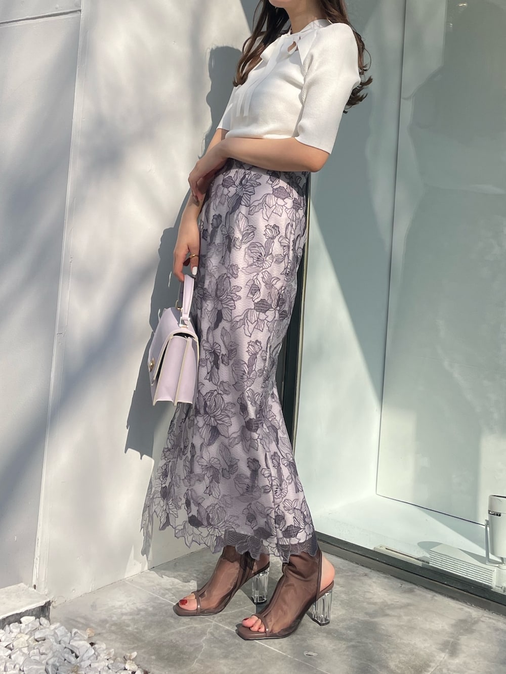 ホワイト系のスカート、ホワイト系のニット/セーター、ブラック系のブーツを着用したレディースの春コーディネートの3枚目の写真