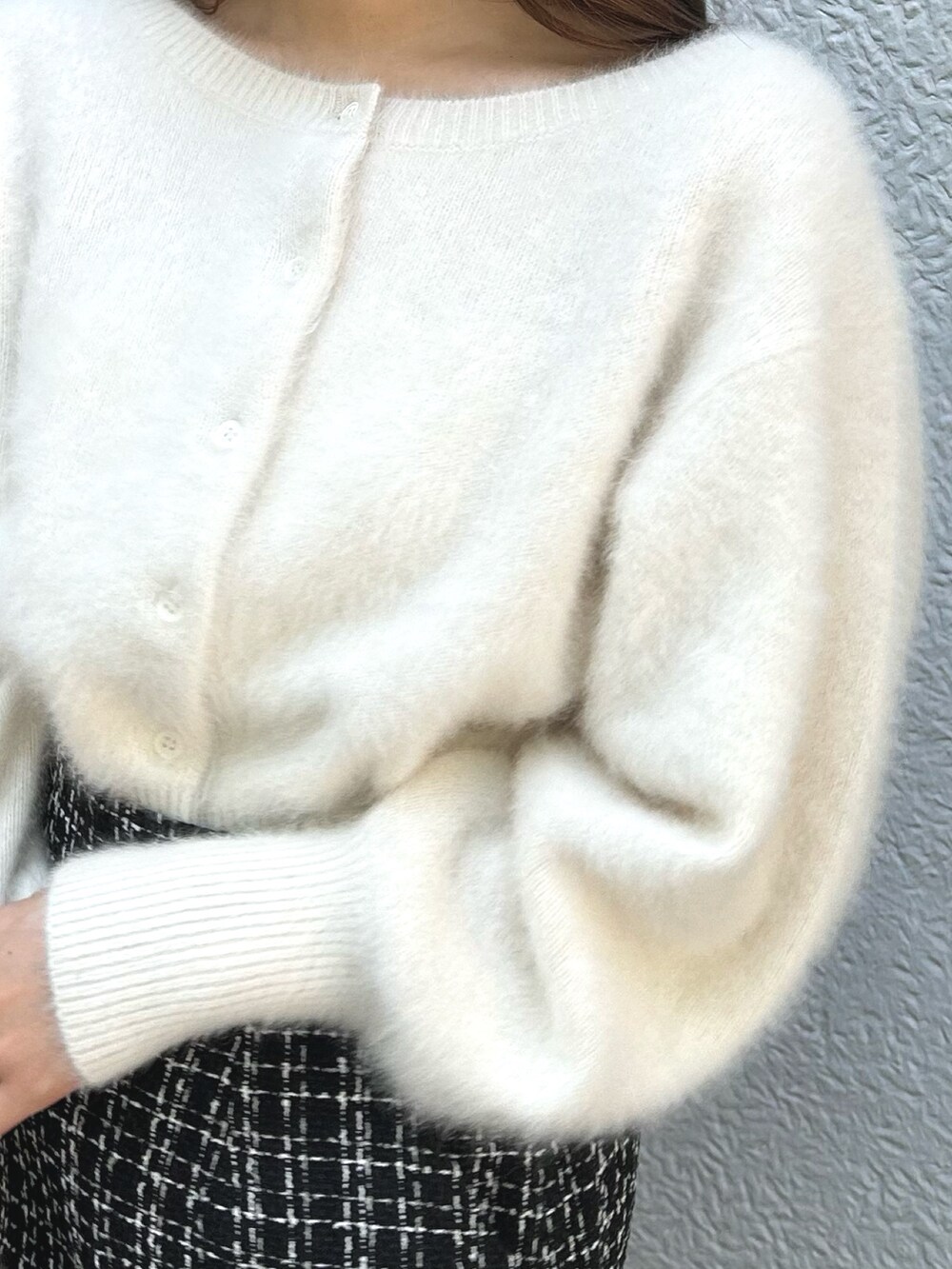 ホワイト系のカーディガン/ボレロ、ブラック系のスカート、ブラック系のブーツを着用したレディースの秋コーディネートの5枚目の写真