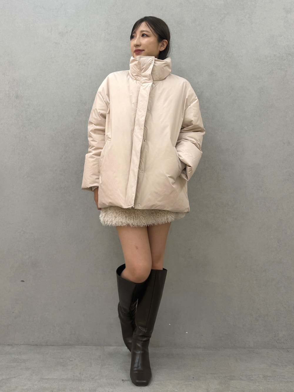 ピンク系のダウンジャケット/コート、ホワイト系のスカート、ブラウン系のブーツを着用したレディースの秋コーディネートの2枚目の写真