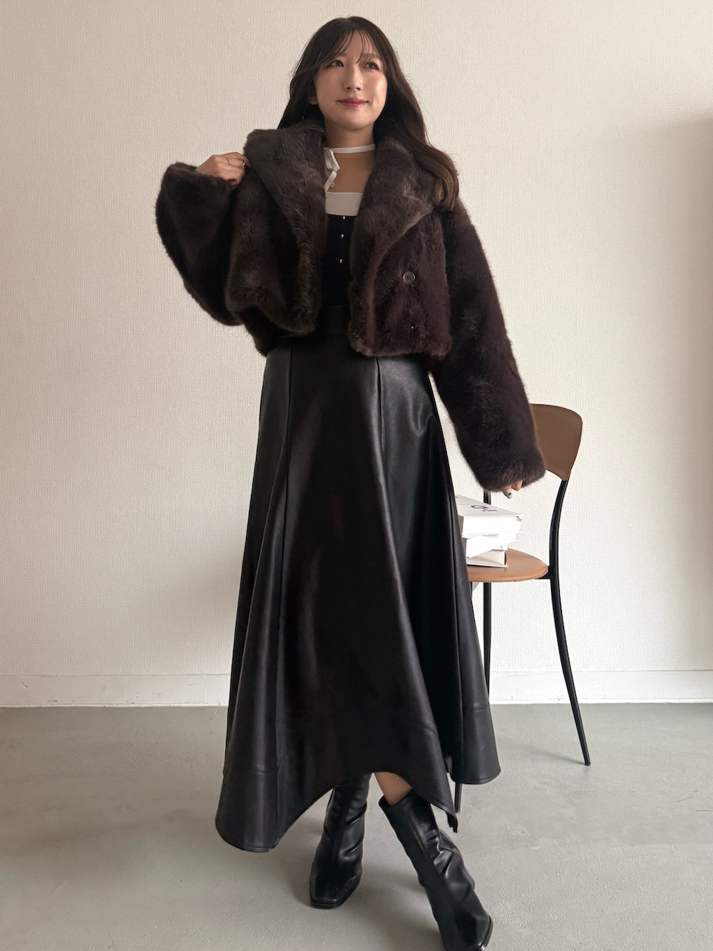 ブルー系のニット/セーター、ブラウン系のその他アウター、ブラック系のスカートを着用したレディースの秋コーディネートの2枚目の写真