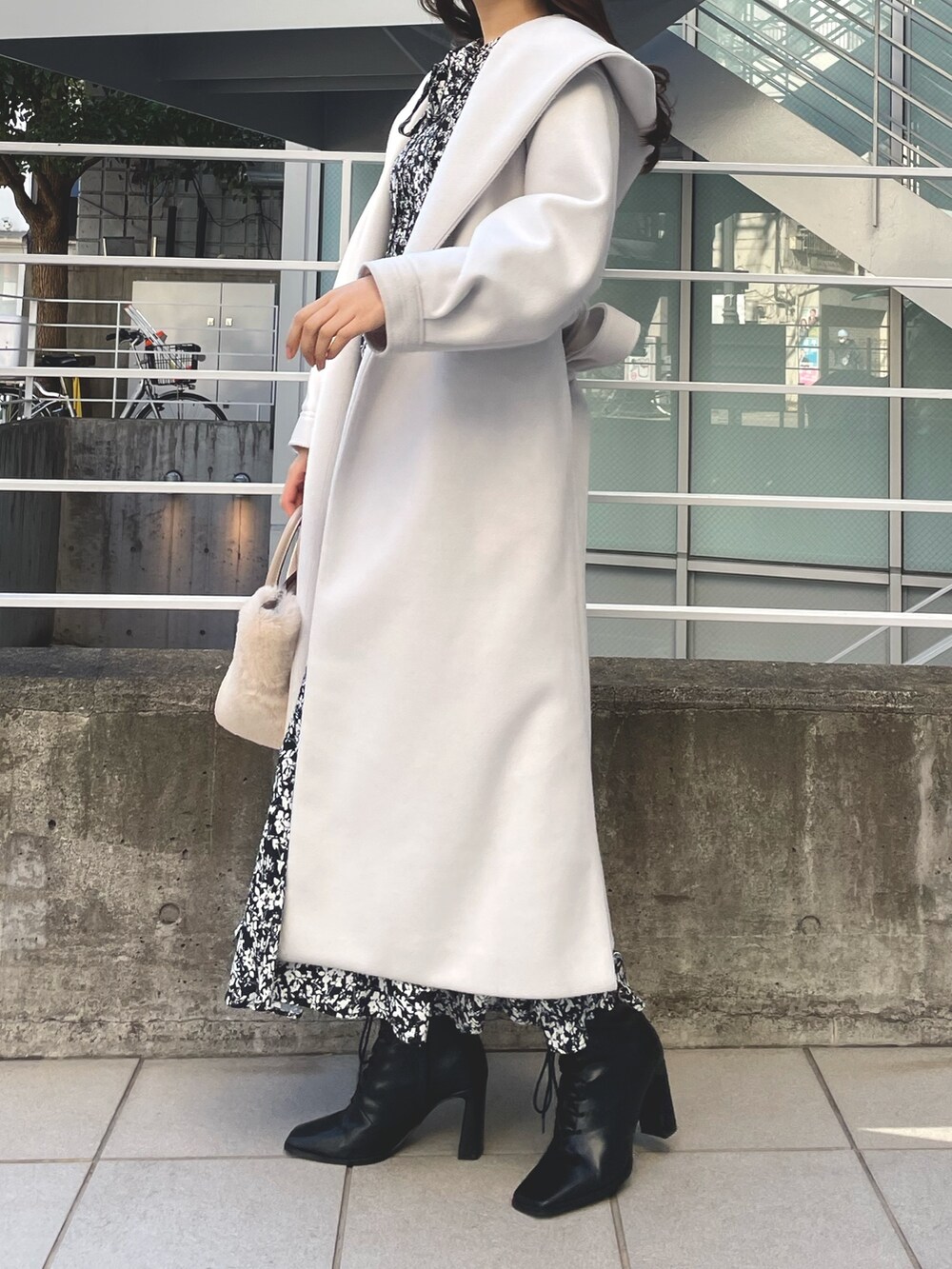 ホワイト系のチェスターコート、ブラック系のワンピース、ブラック系のブーツを着用したレディースの冬コーディネートの2枚目の写真