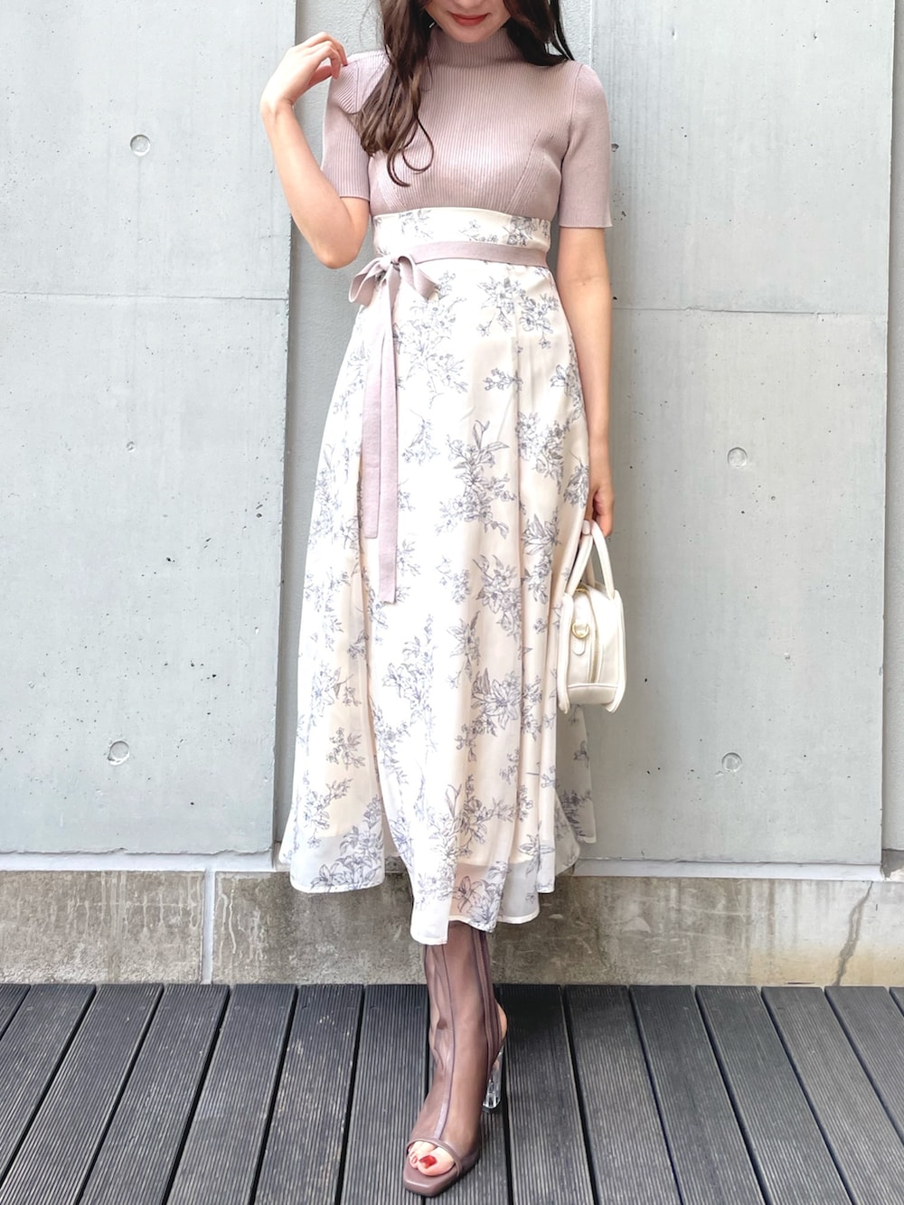 ブラック系のブーツ、ブラック系のハンドバッグ、ホワイト系のワンピースを着用したレディースの春コーディネートの2枚目の写真