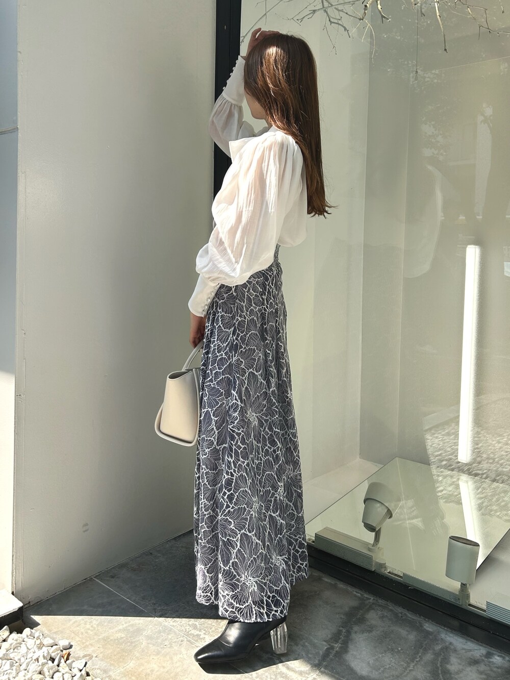 ブラック系のライダースジャケット、ホワイト系のシャツ/ブラウス、ブルー系のスカートを着用したレディースの夏コーディネートの5枚目の写真