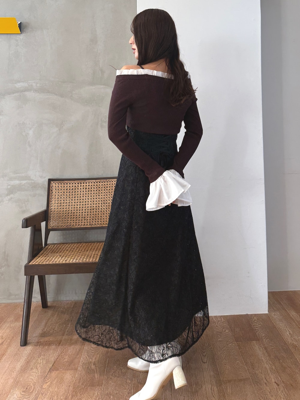 ブラウン系のニット/セーター、ブラック系のスカート、ホワイト系のブーツを着用したレディースの秋コーディネートの4枚目の写真