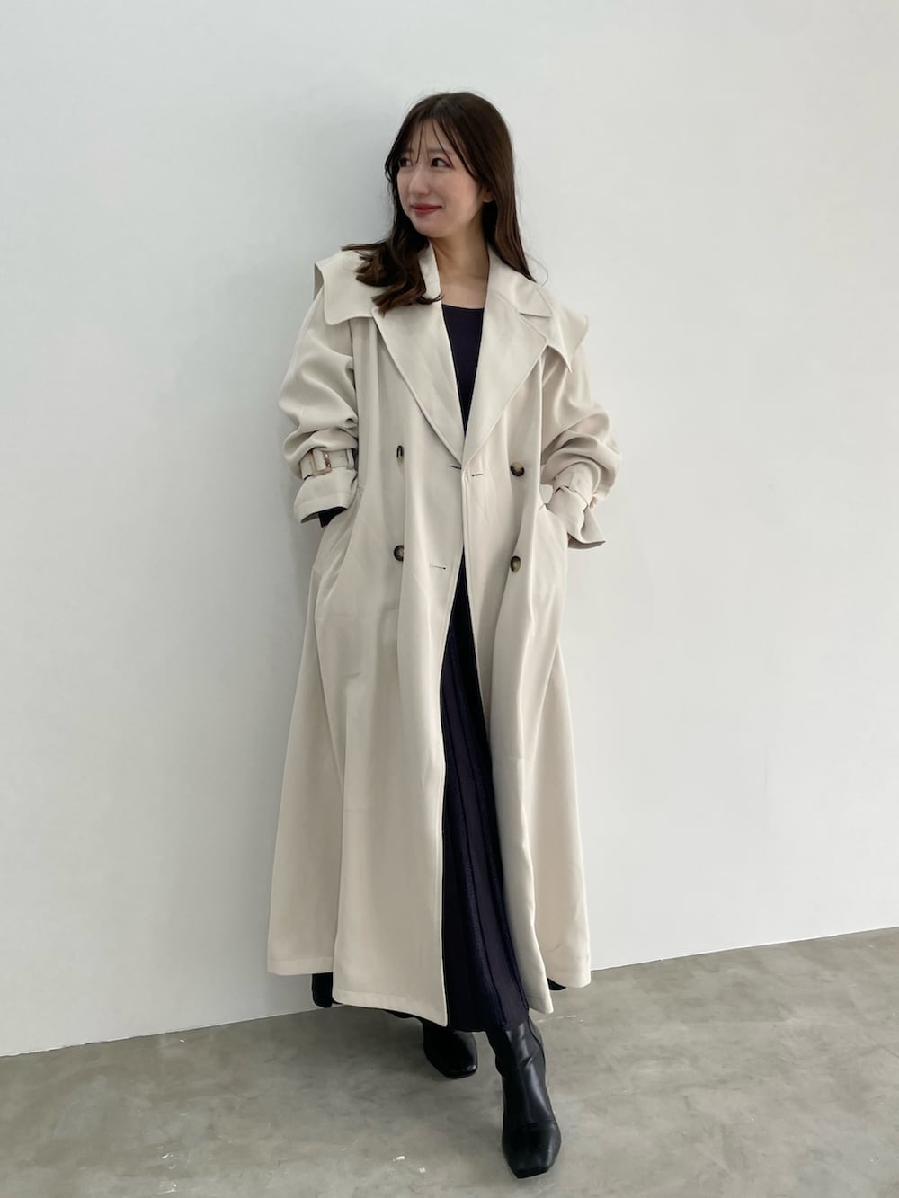 グレー系のワンピース、ホワイト系のトレンチコートを着用したレディースの冬コーディネートの5枚目の写真