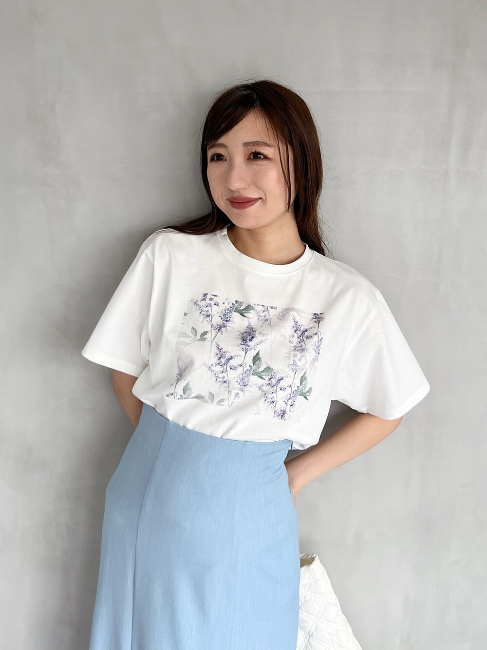 ブルー系のスカート、シルバー系のサンダル、ホワイト系のハンドバッグを着用したレディースの夏コーディネートの3枚目の写真