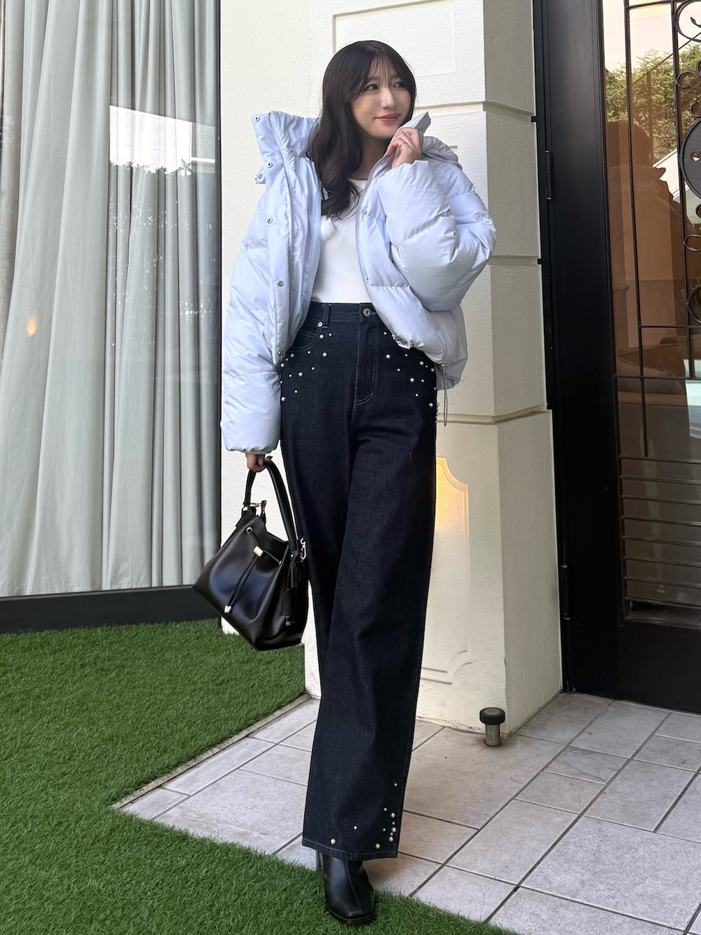 ホワイト系のニット/セーター、ブルー系のダウンジャケット/コート、ブルー系のデニムパンツを着用したレディースの秋コーディネートの5枚目の写真