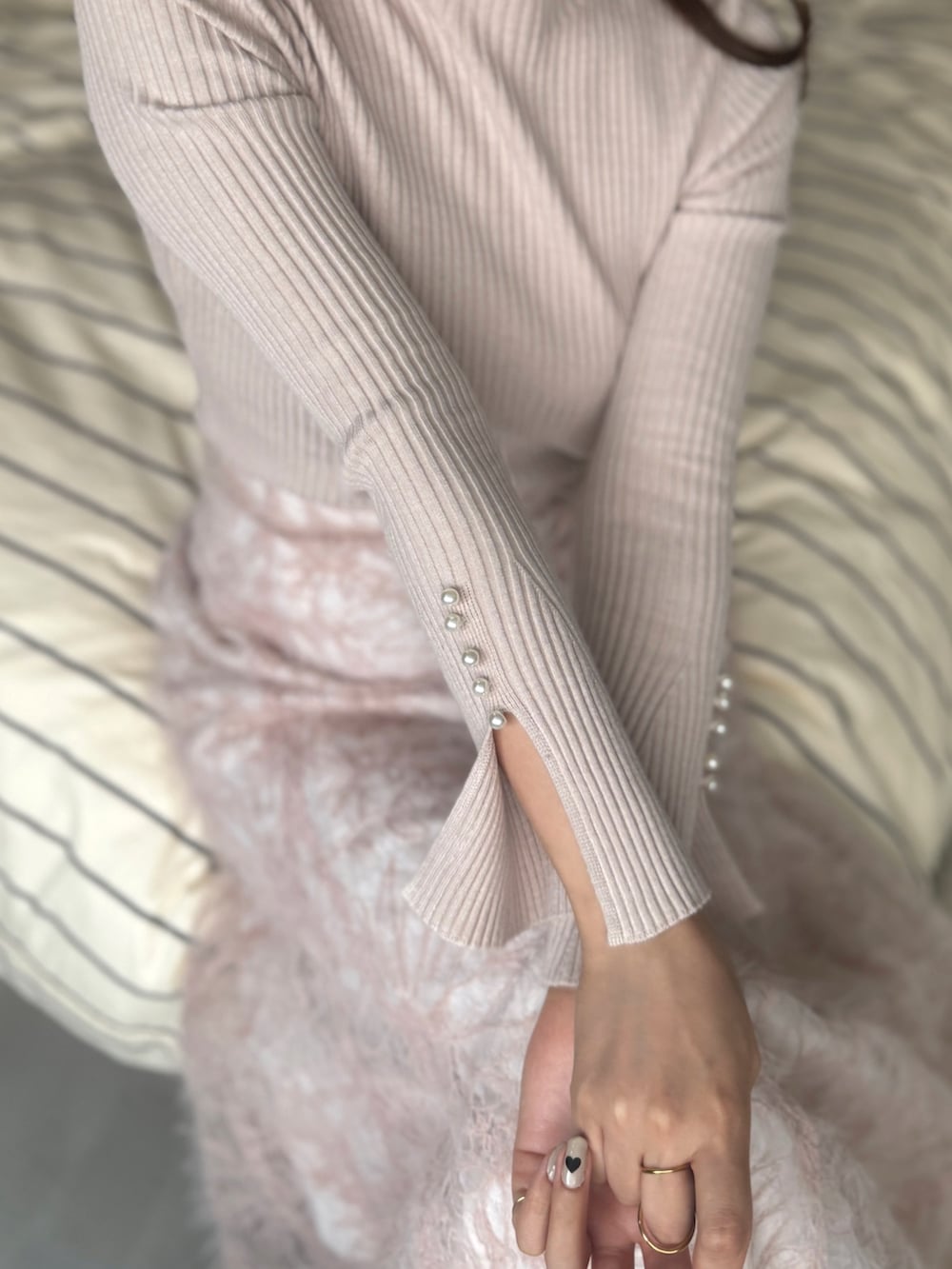 ベージュ系のニット/セーター、ピンク系のスカート、ブラック系のパンプスを着用したレディースの秋コーディネートの3枚目の写真