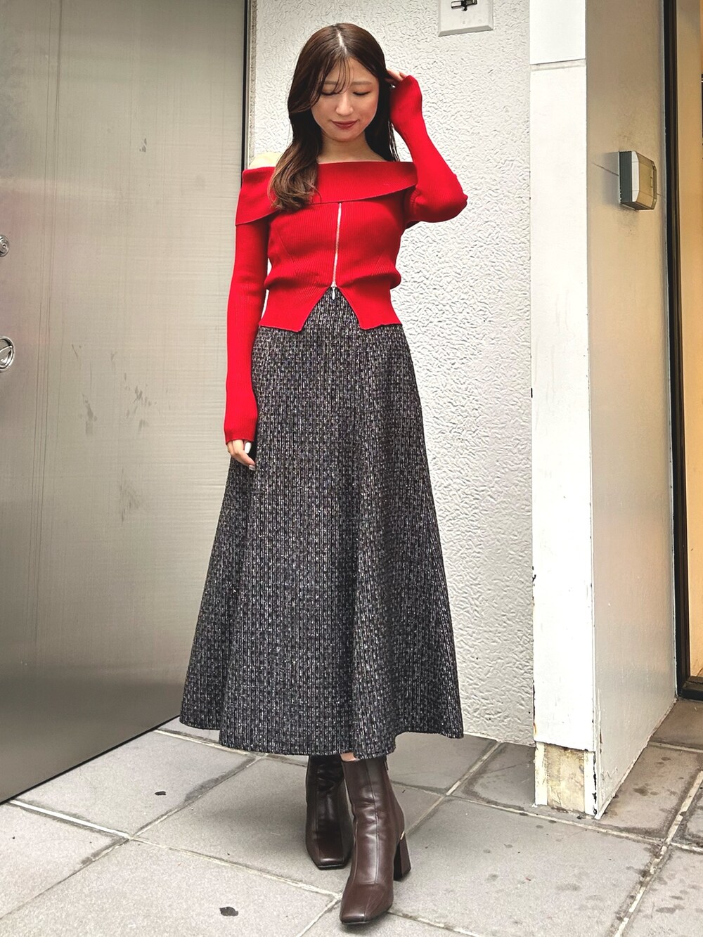 レッド系のニット/セーター、グレー系のその他アウター、ブラウン系のブーツを着用したレディースの冬コーディネートの2枚目の写真