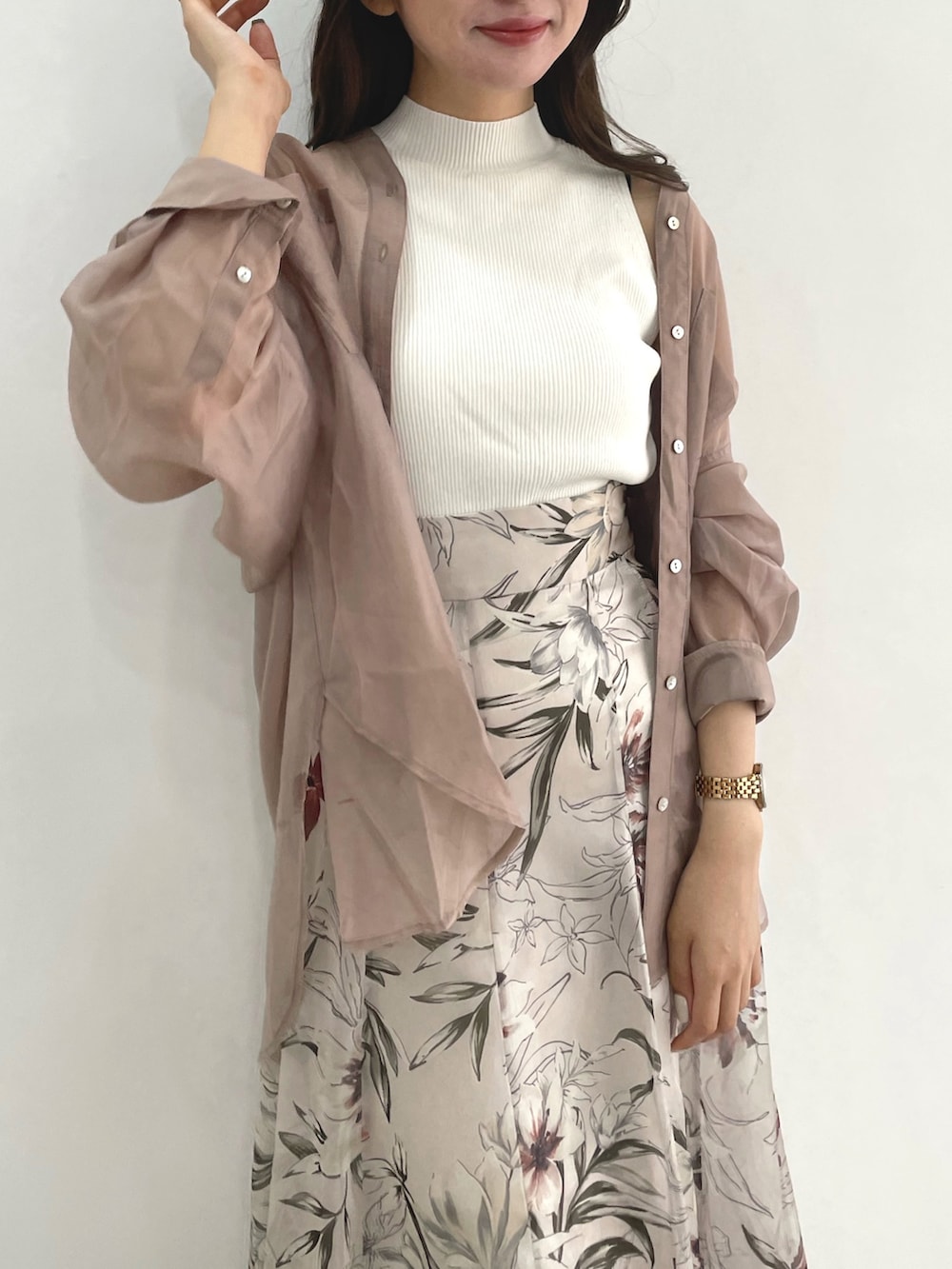 ピンク系のスカート、ホワイト系のニット/セーター、ベージュ系のシャツ/ブラウスを着用したレディースの春コーディネートの3枚目の写真